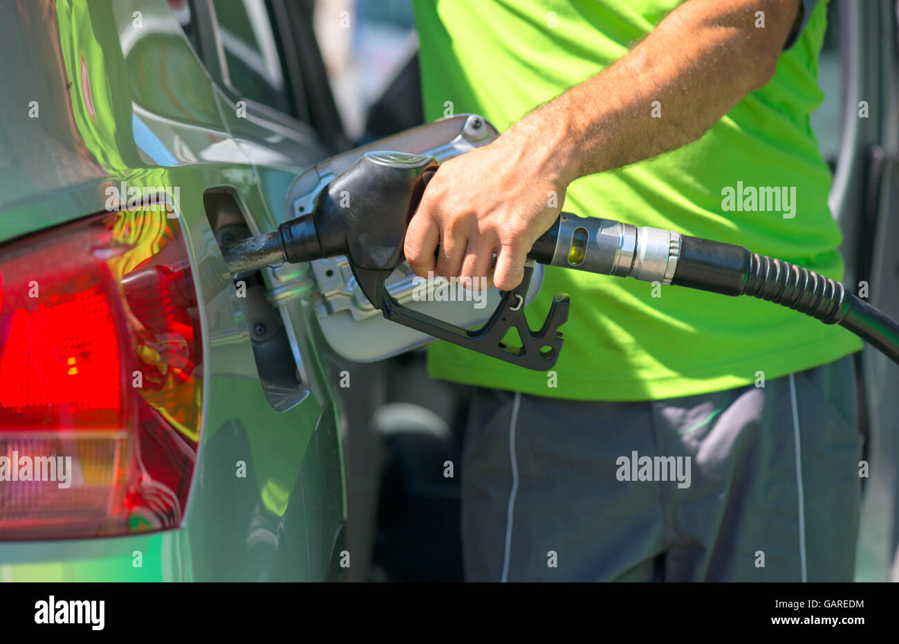 Pumping gas at gas station. Close up of a hand holding fuel nozzle