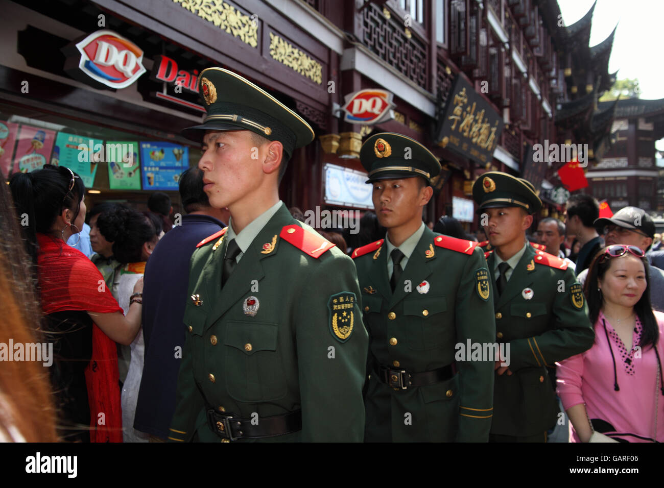 Uniformed Chinese soldiers walk in the crowd of tourists in the historical Yuyuan quarter. Shanghai, China. Apr., 2016. Stock Photo