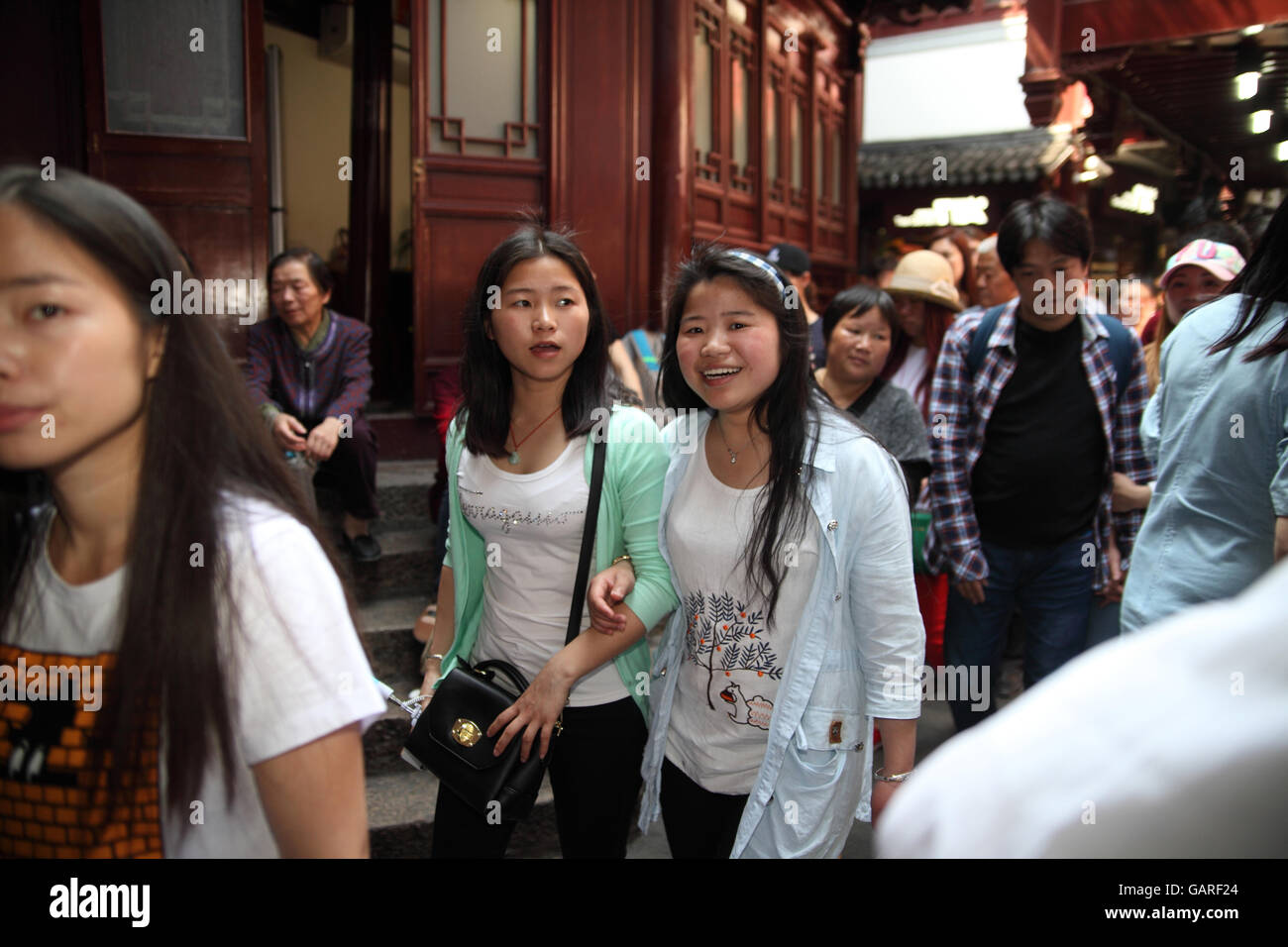Young and happy Chinese women and many other tourists walk in the historical Yuyuan neighborhood. Shanghai, China. Apr., 2016. Stock Photo