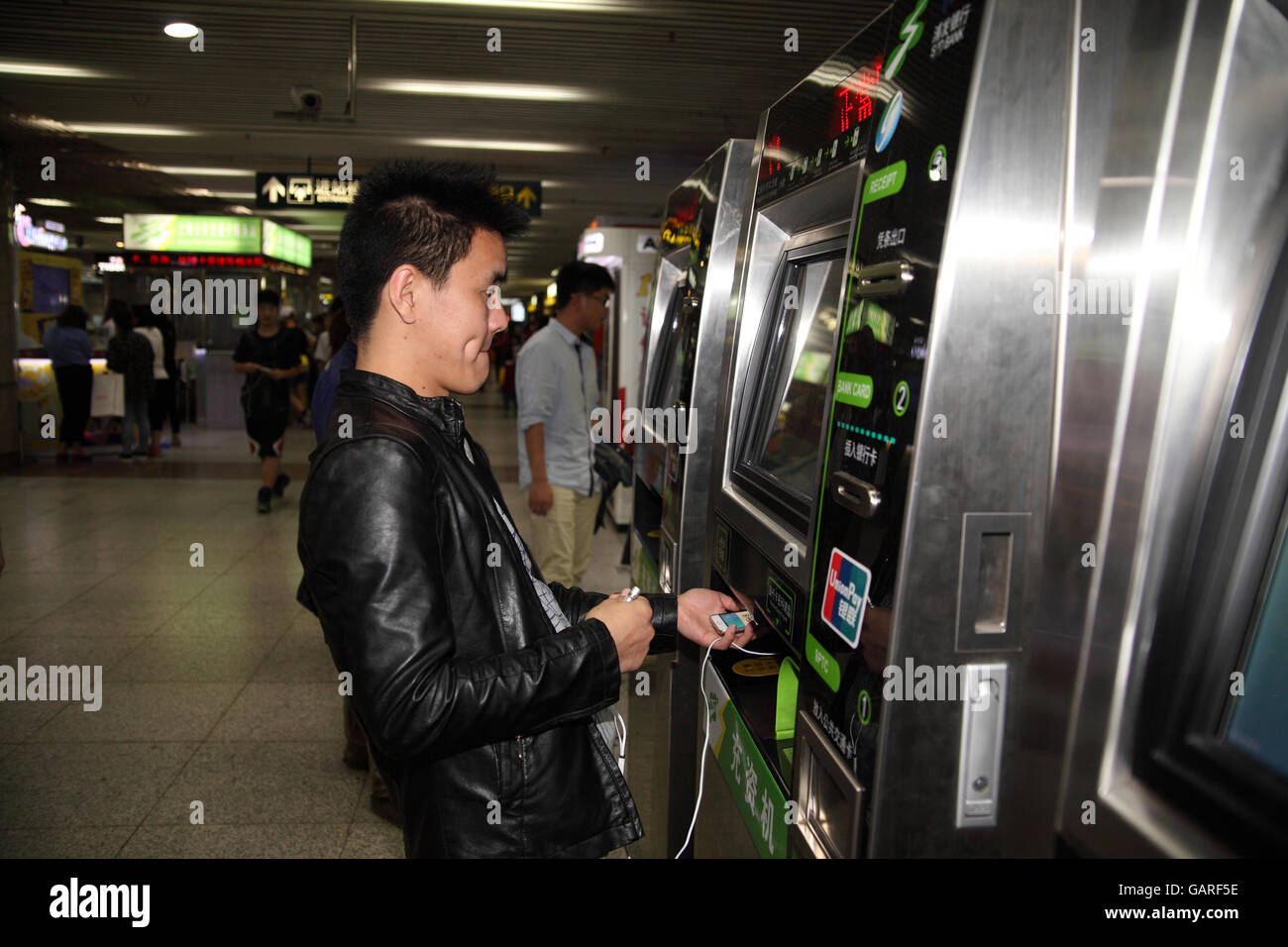 A Young Man Puts His Shanghai Public Transportaion Card In A Machine At The Zhongshan Station To 