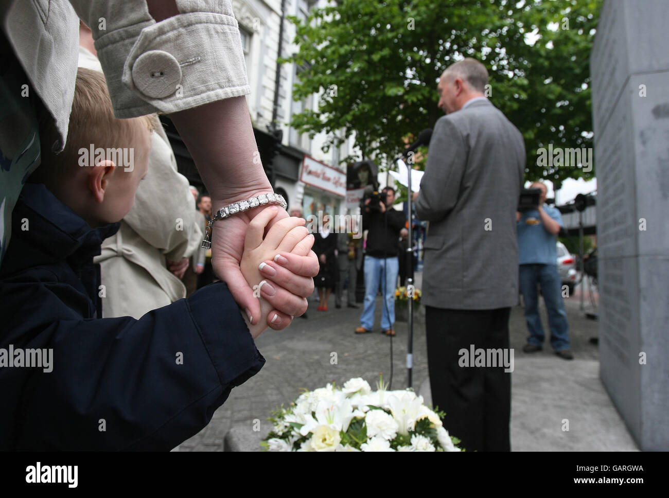 Five year old Shane Byrne, whose grandmother Anne Byrne was one of those killed in the 1974 Dublin Monaghan bombings, listens to Kevin O'Laughlin of campaign group justice for the forgotten during the 34th annual commemoration in Dublin's Talbot Street. Stock Photo