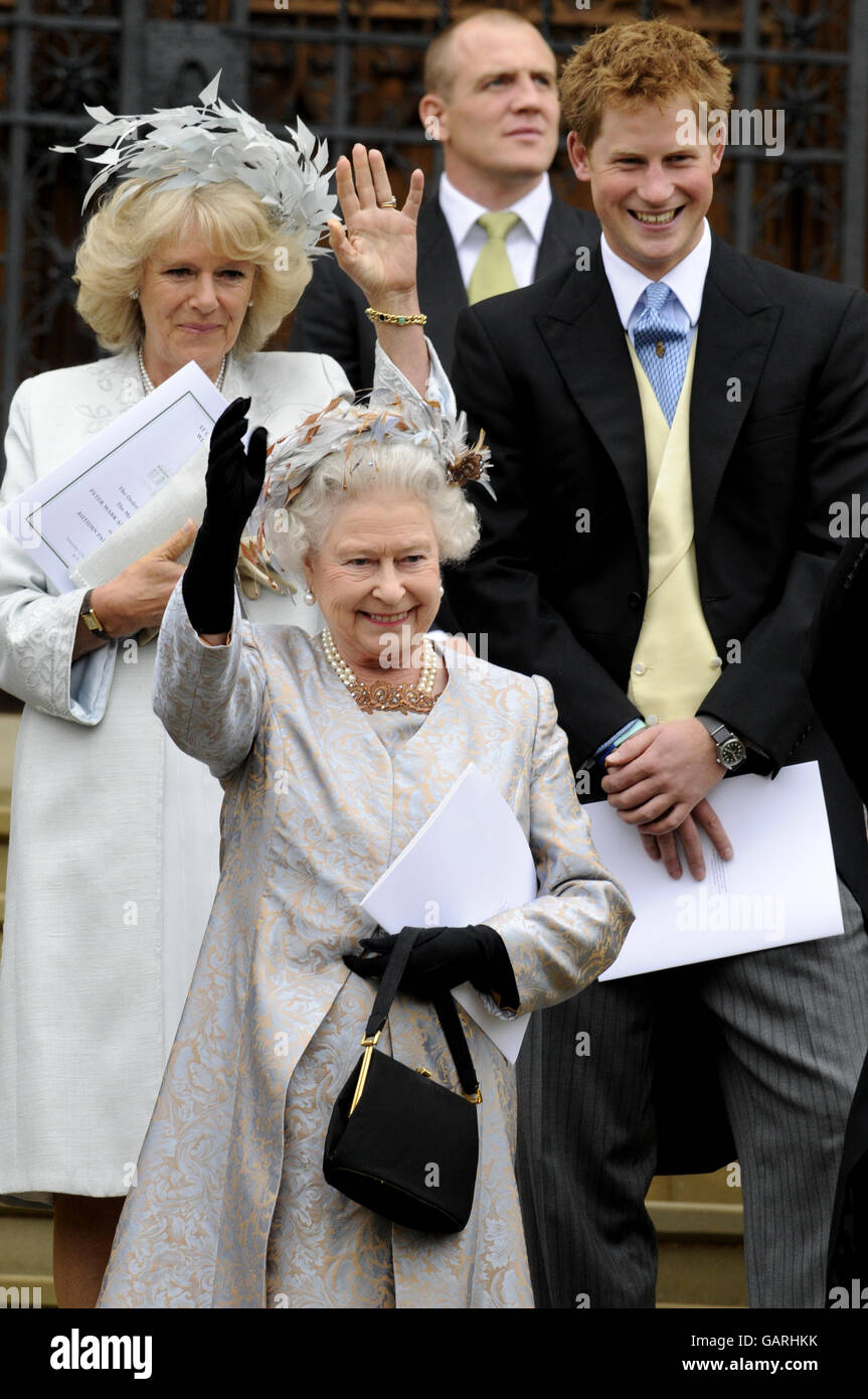 Queen Elizabeth II waves off her eldest grandson Peter Phillips and Autumn Kelly as she leave St. George's Chapel in Windsor, England, after the marriage ceremony of the Princess Royal's son. Stock Photo