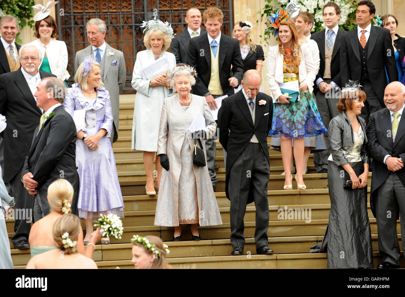 Queen Elizaberth II waves off her eldest grandson Peter Phillips and Autumn Kelly as she leave St. George's Chapel in Windsor, England, after the marriage ceremony of the Princess Royal's son. Stock Photo