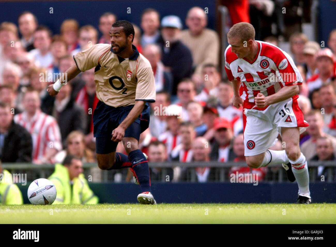 Arsenal's Ashley Cole (l) gets away from Sheffield United's John Curtis (r) Stock Photo