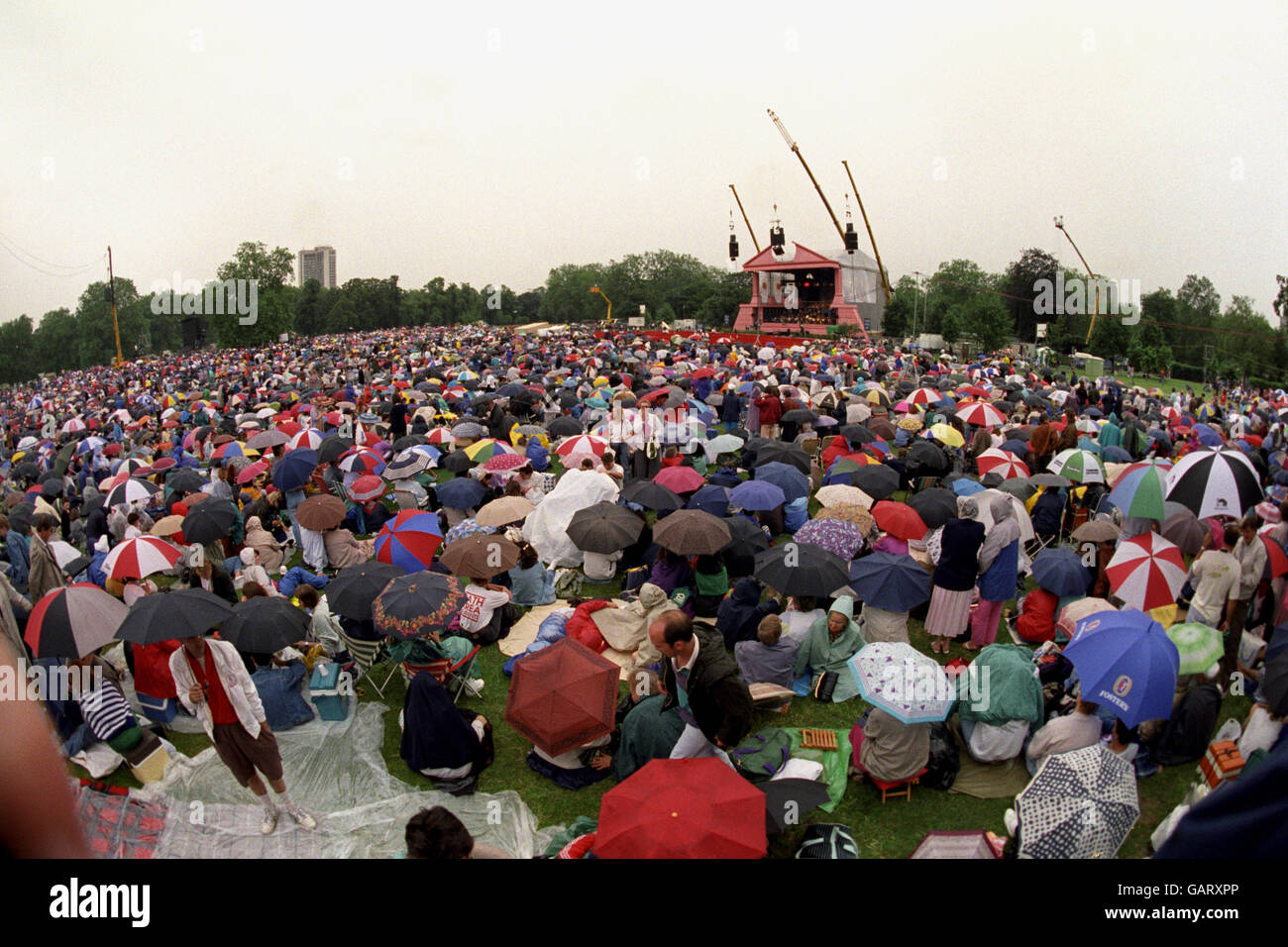 Fans wait in the rain for the start of the open air concert by Luciano Pavarotti. Stock Photo