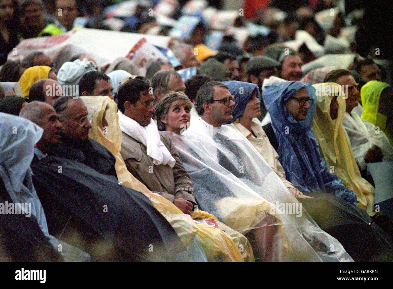 Left to right, The Prince and Princess of Wales, Prime Minister John Major and the Duchess of York brave the weather for the open air concert by Luciano Pavarotti. Stock Photo