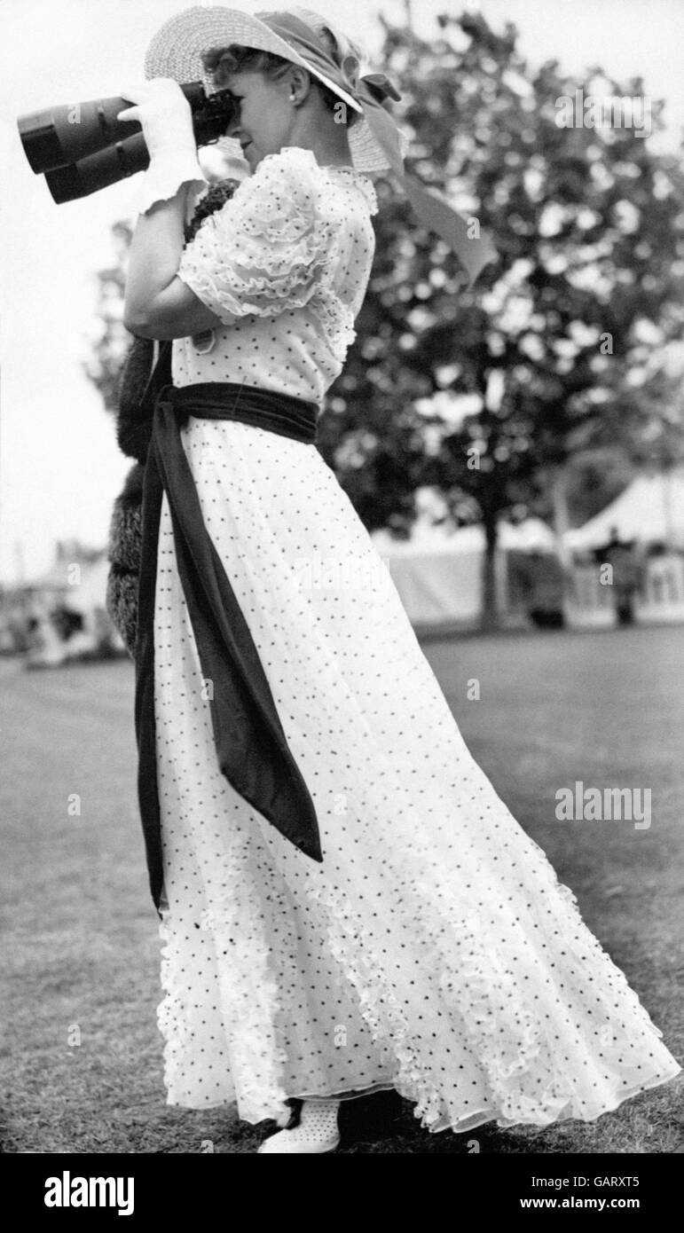 Mrs W Boulton watches the racing through a pair of high-powered binoculars. Stock Photo