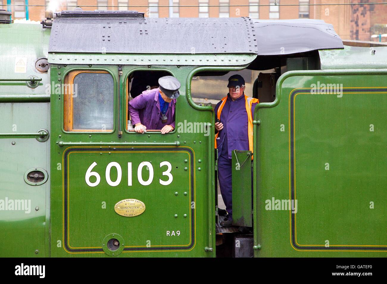 Engine driver & fireman in the cab of steam train LNER A3 Class 4-6-2 no 60103 Flying Scotsman. Carlisle Railway Station, UK. Stock Photo
