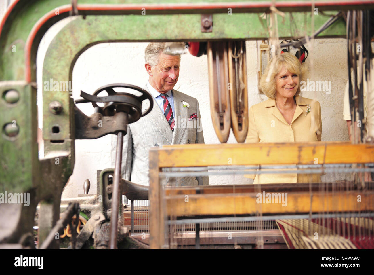 The Prince of Wales and the Duchess of Cornwall watch wool being weaved during their tour of Solva Woolen Mill, Solva, Wales. Stock Photo