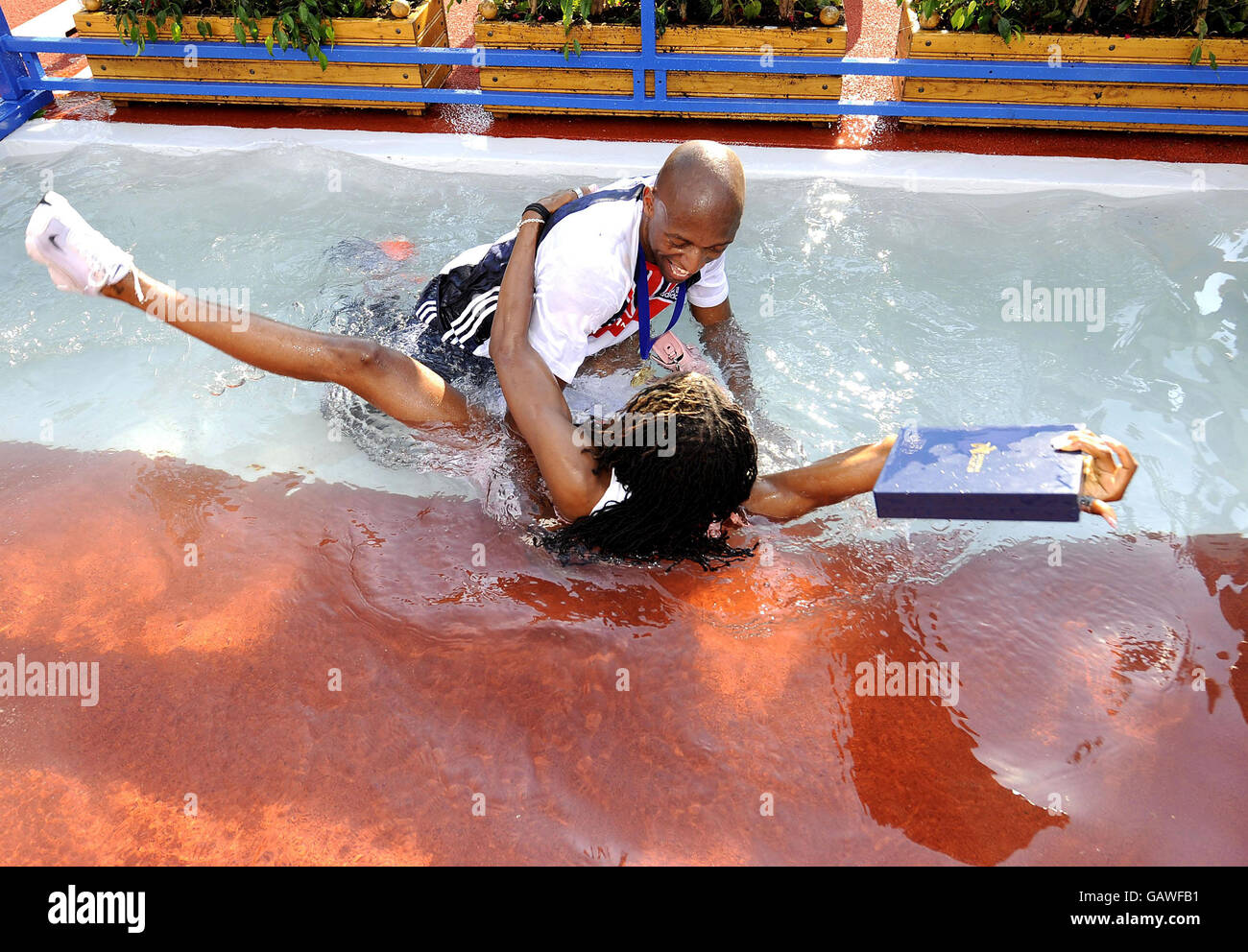 The GB Men's Athletics team celebrate their victory in the Event at the Spar European Cup at as they throw their captain Marlon Devonish into the Water Jump where he is joined by Natasha Danvers the Womens Team Captain at Annecy, France. Stock Photo