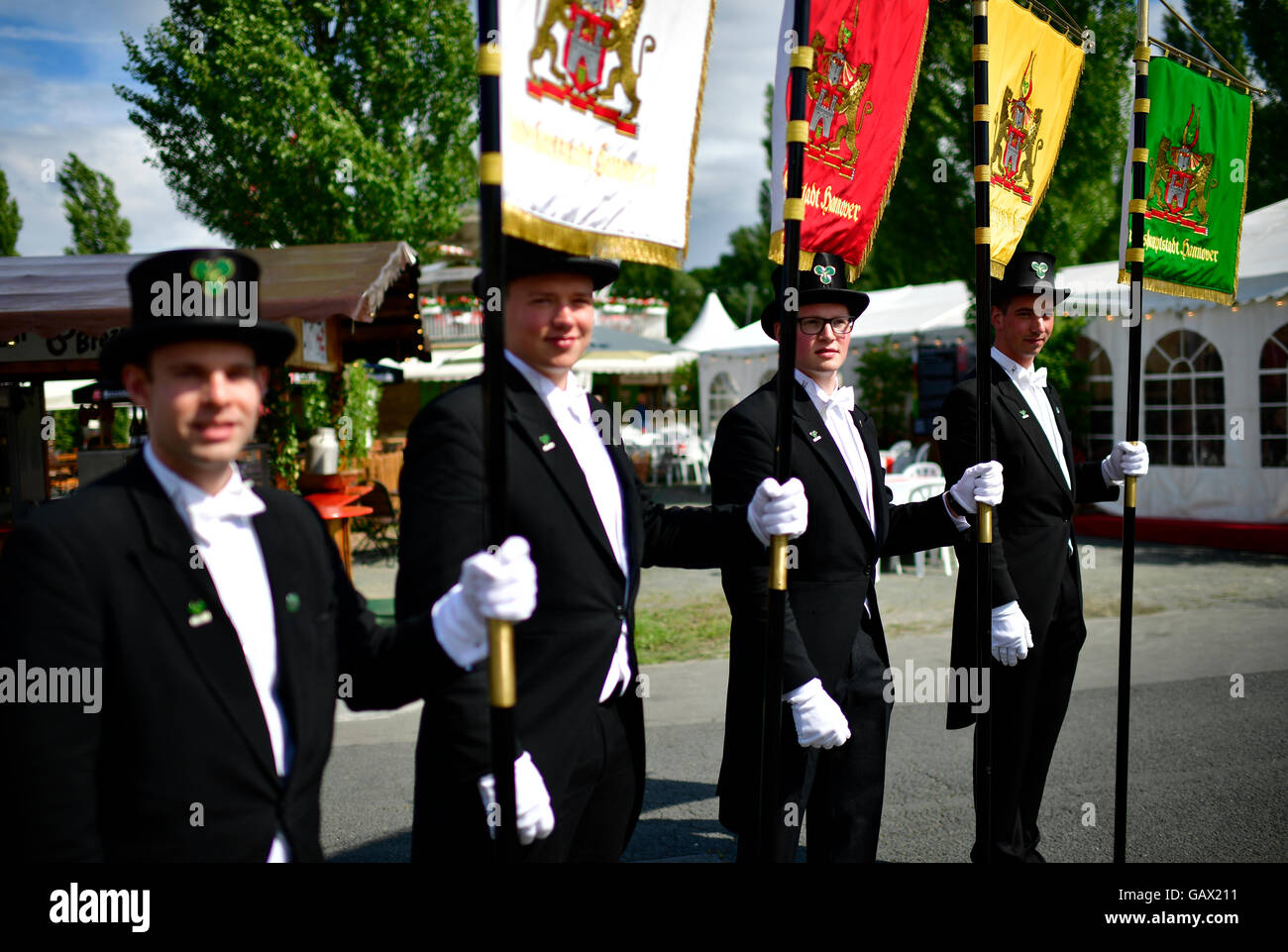 Hannover, Germany. 6th July, 2016. Bruchmeisters Maximilian Bode-Meyer (l-r), Norman Hennies, Markus Hirte and Dennis Wellner carry their guidons across marksmen's festival Hannover in Hannover, Germany, 6 July 2016. It has been the custom since 1303 that the four special guards care for security in the city. Photo: Alexander Koerner/dpa/Alamy Live News Stock Photo