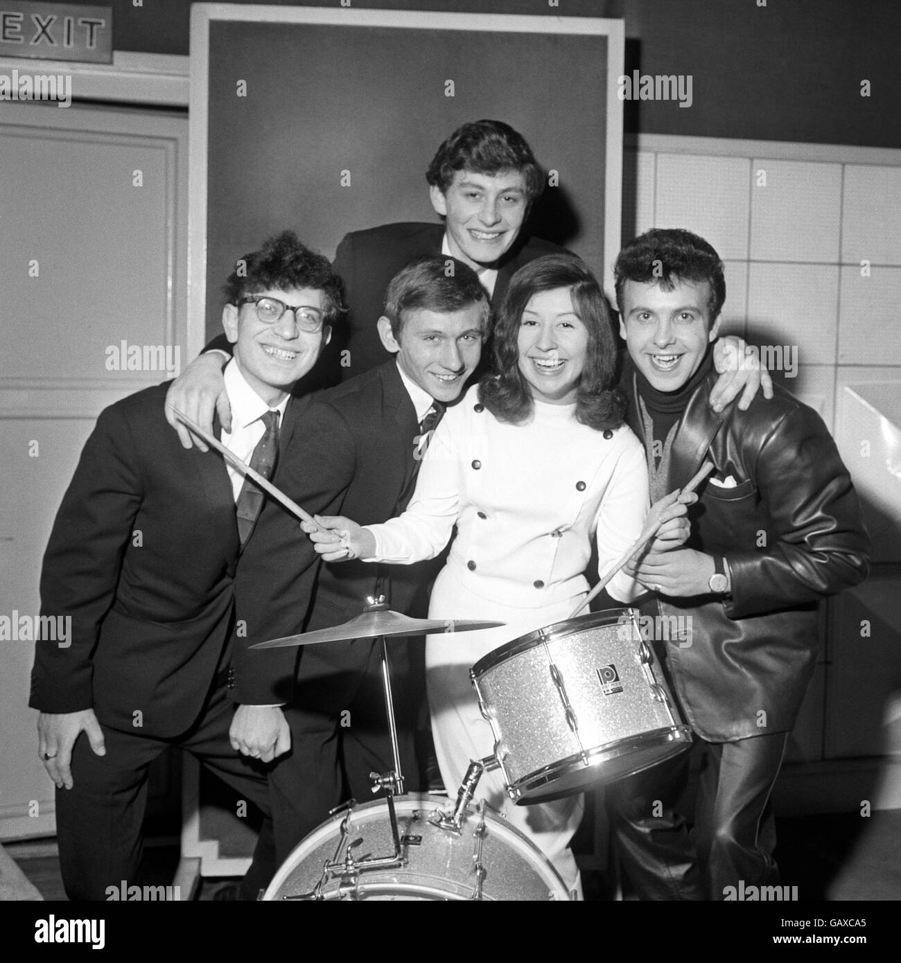 Girl drummer wearing a white leather suit catches the eye in the 'pop' music group, The Ravens, introduced to the press in London this morning. Her name is Tina Ambrose, she's 16 and was born in London. With her are - from left to right: Conred Wagner, 25 from Stepney, East London; Brian Goldson, 18 from St. John's Wood, London, Tony Hart (top), he's 19 and comes from Clapham, and Tony Miles, 20 from Cardiff. They have just made their first record, 'I Just Wanna Hear You Say (I Love You) Stock Photo