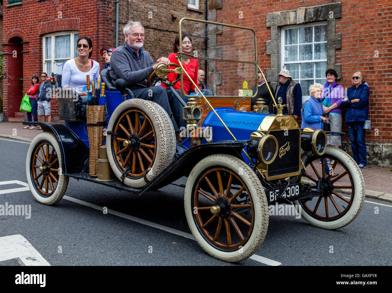 An Old Fashioned Car Takes Part In A Street Procession During The St Lawrence Fair, Hurstpierpoint, Sussex, UK Stock Photo