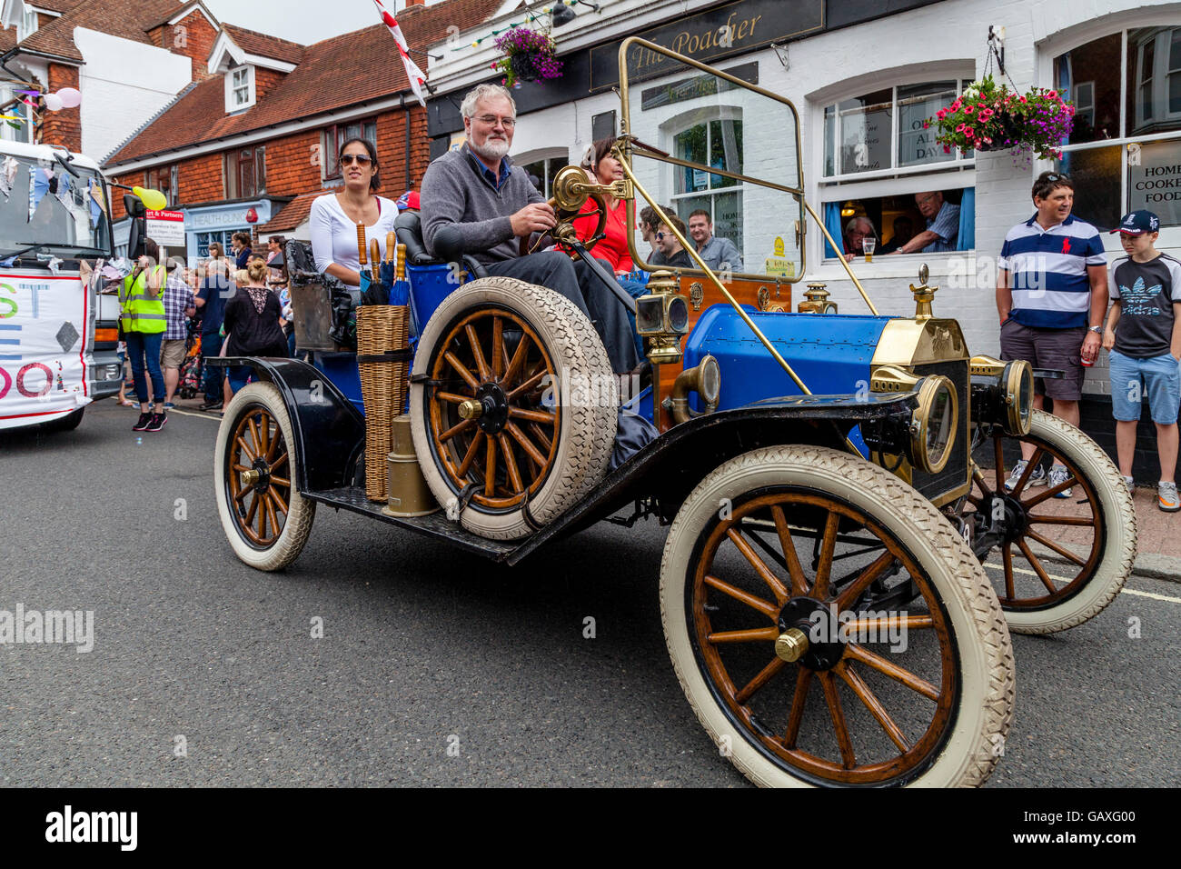 An Old Fashioned Car Takes Part In A Street Procession During The St Lawrence Fair, Hurstpierpoint, Sussex, UK Stock Photo