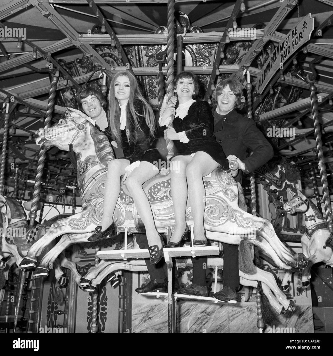 Swinging into a round of happiness on the 'Thundering Horses' at the Battersea Festival Gardens and Fun Fair are 'The Chanters'. Stock Photo