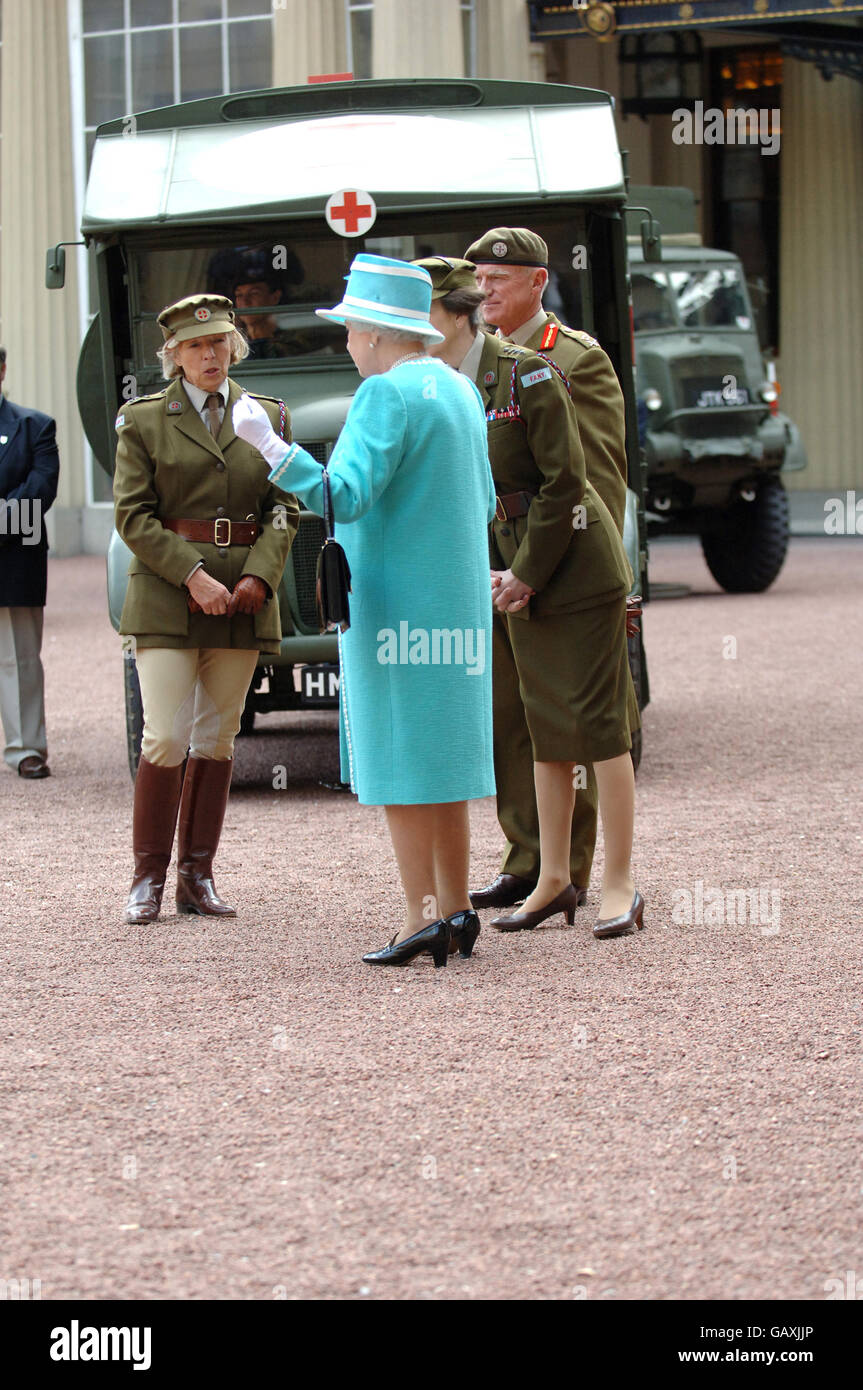 The Queen and The Princess Royal, who is Commandant-in-Chief of the First Aid Nursing Yeomany, arrives to inspect vintage vehicles used by the yeomanry after they assembled in the quadrangle of Buckingham Palace, London to mark the centenary of the yeomanry. Stock Photo