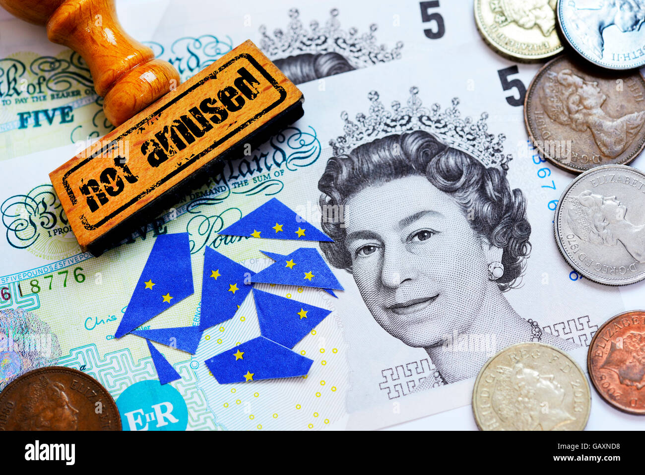 Pound notes and coins, not amused stamp and torn EU flag Stock Photo