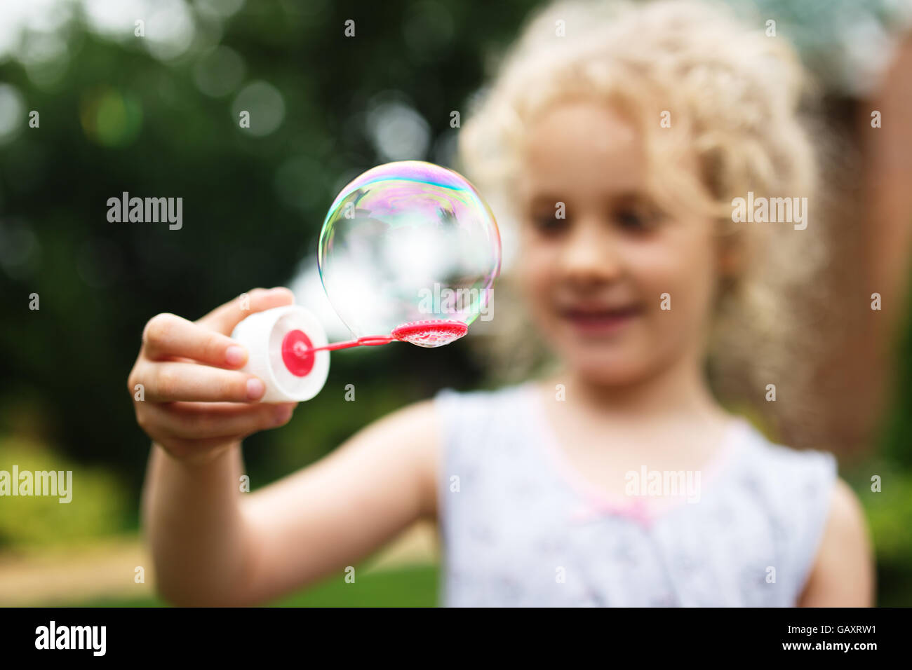 Cute little girl is blowing a soap bubbles and having fun Stock Photo ...