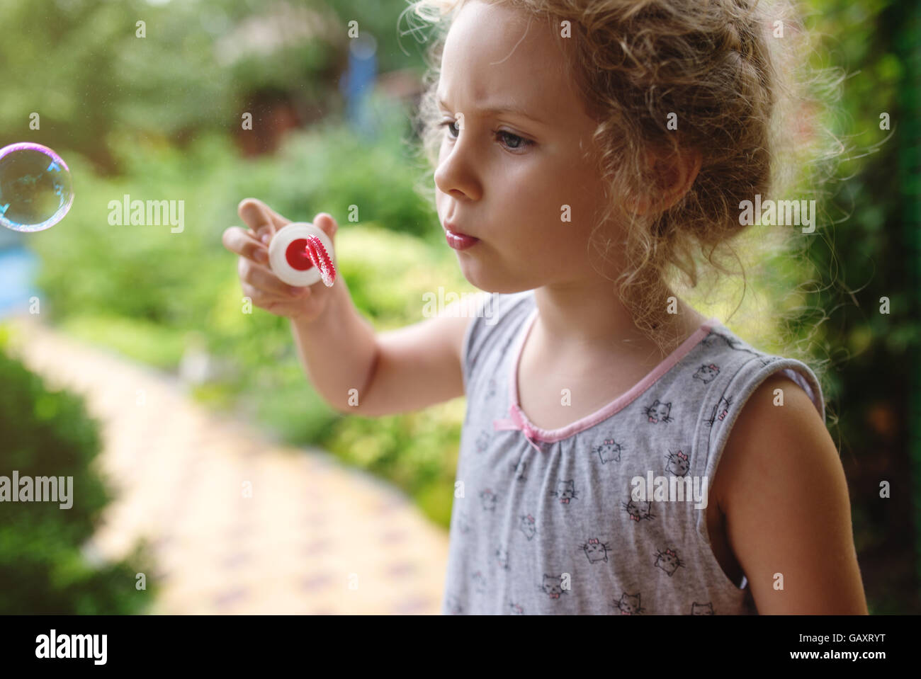 Cute little girl is blowing a soap bubbles and having fun Stock Photo ...