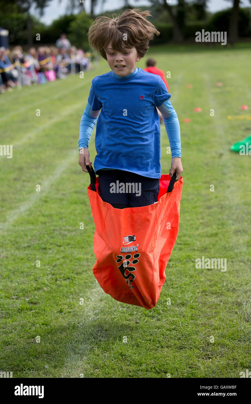 Boy competing in sack race St James Primary School sports day Chipping Campden UK Stock Photo