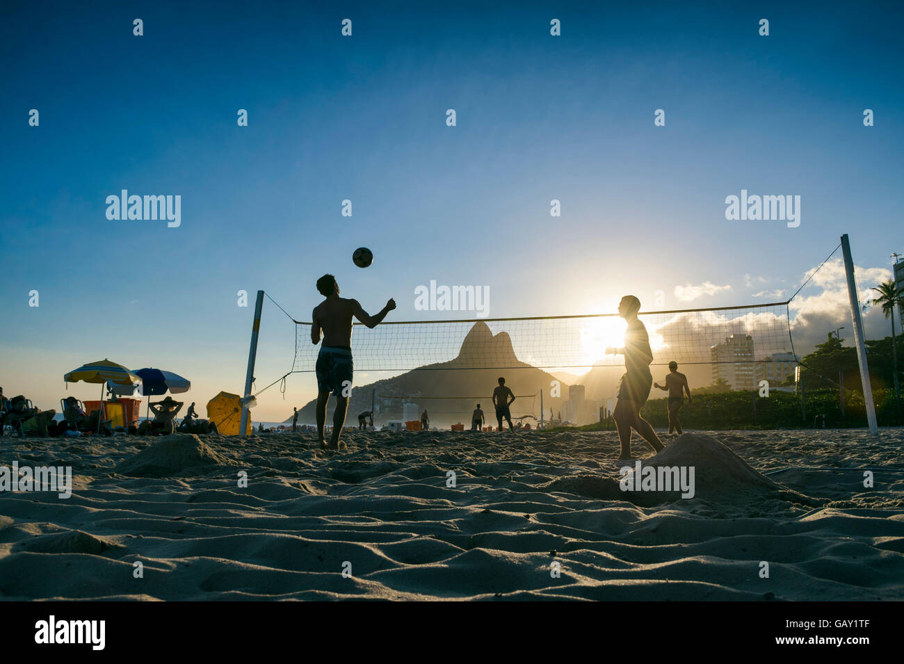 Silhouettes of Brazilians playing futevolei (footvolley, a game combining football/soccer and volleyball) in Ipanema, Rio Brazil Stock Photo