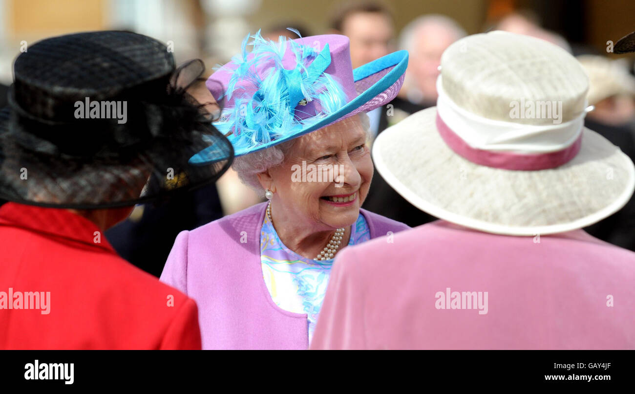 Britain's Queen Elizabeth II meets guests (names not known) as she hosts a garden party in the grounds of Buckingham Palace, London. Stock Photo
