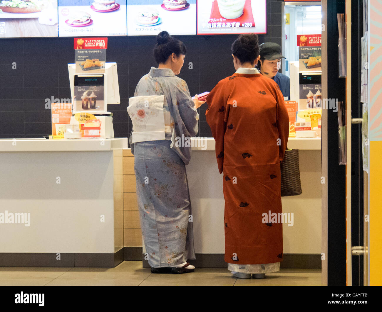 Two women in traditional Japanese dress in a McDonald's store. Stock Photo