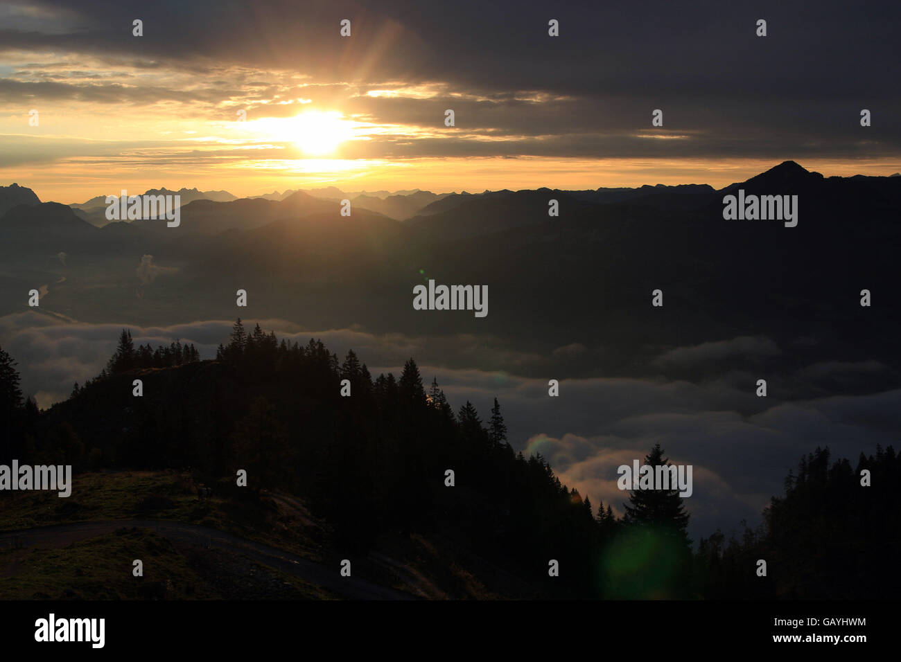 sunset/sunrise in mountains of the alps. Mountains appear as silhouettes because of the light setting. Stock Photo