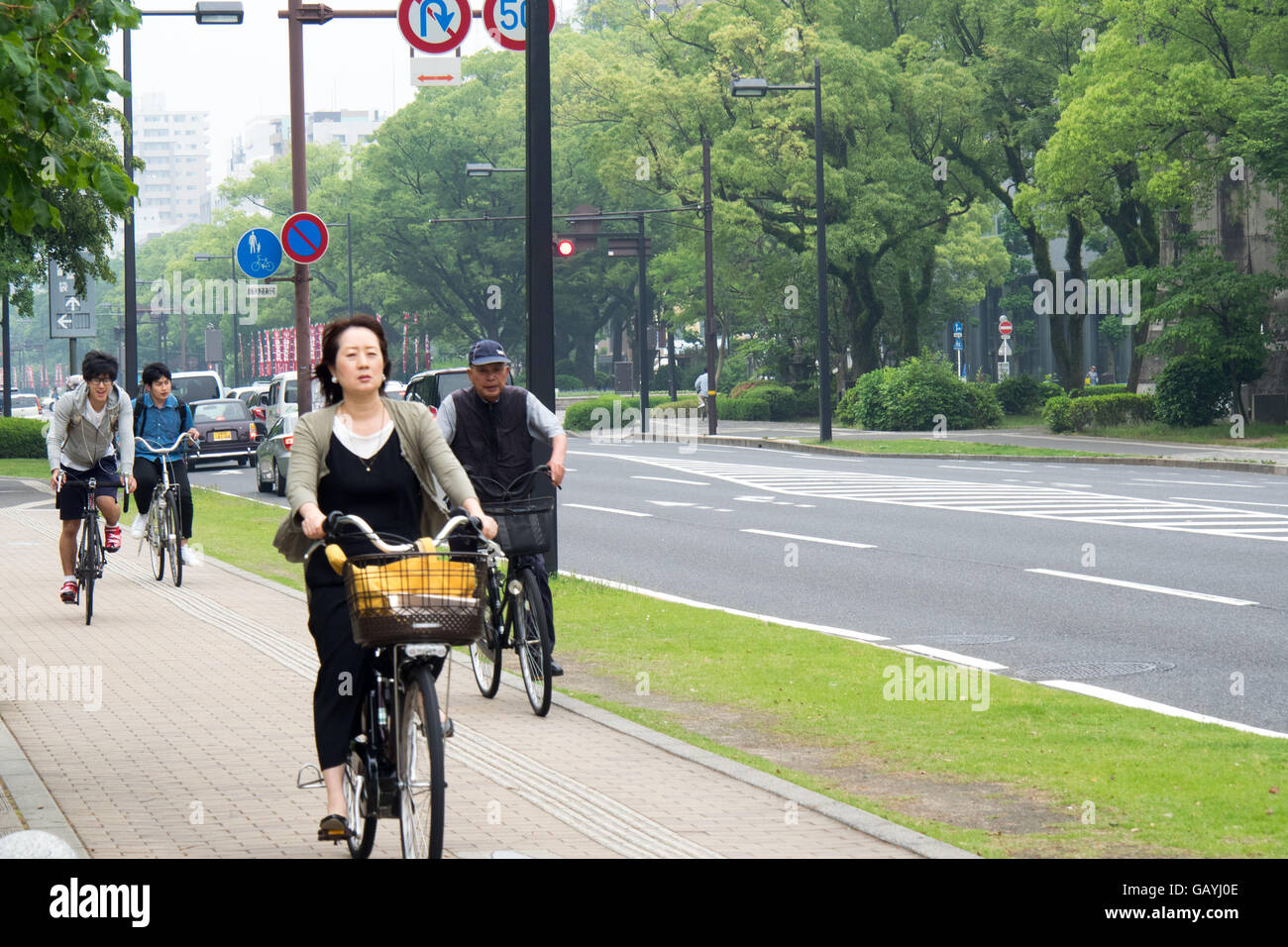 Cyclists commuting along Heiwa Odori, Hiroshima, Japan. Stock Photo