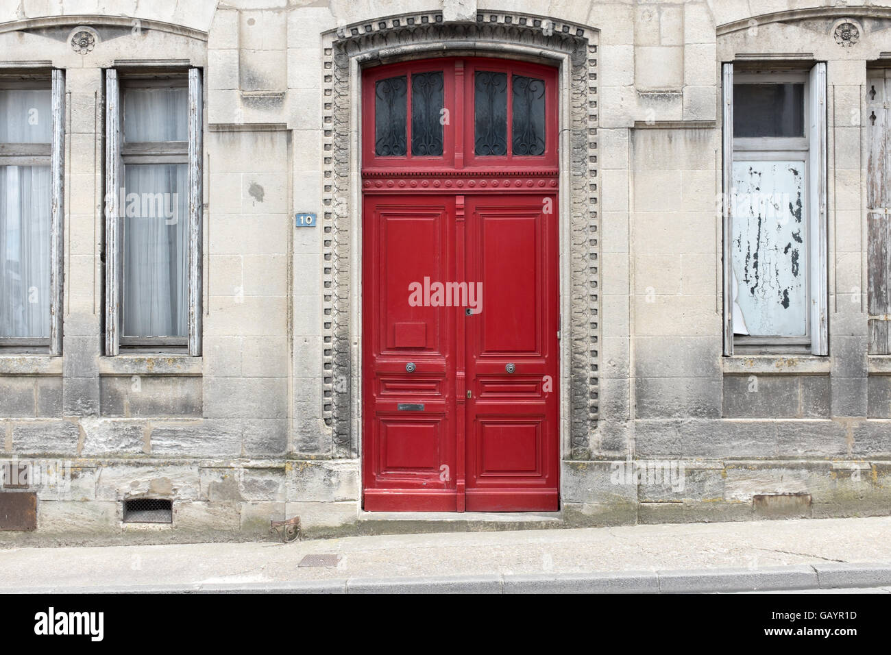 Red wooden double doors at the entrance to an old stone building in ...