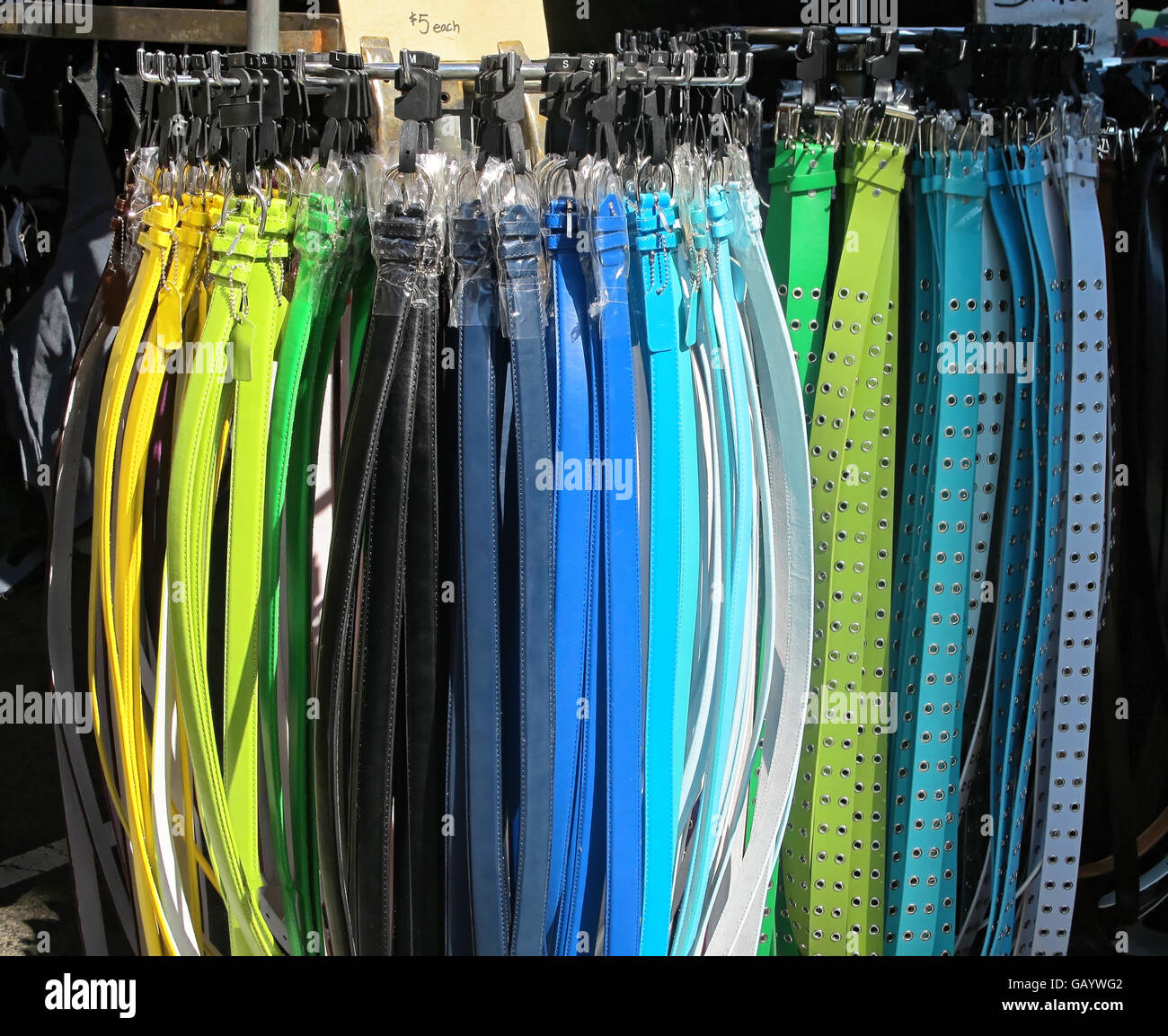 Colorful fashion belts at an outdoor market. Stock Photo