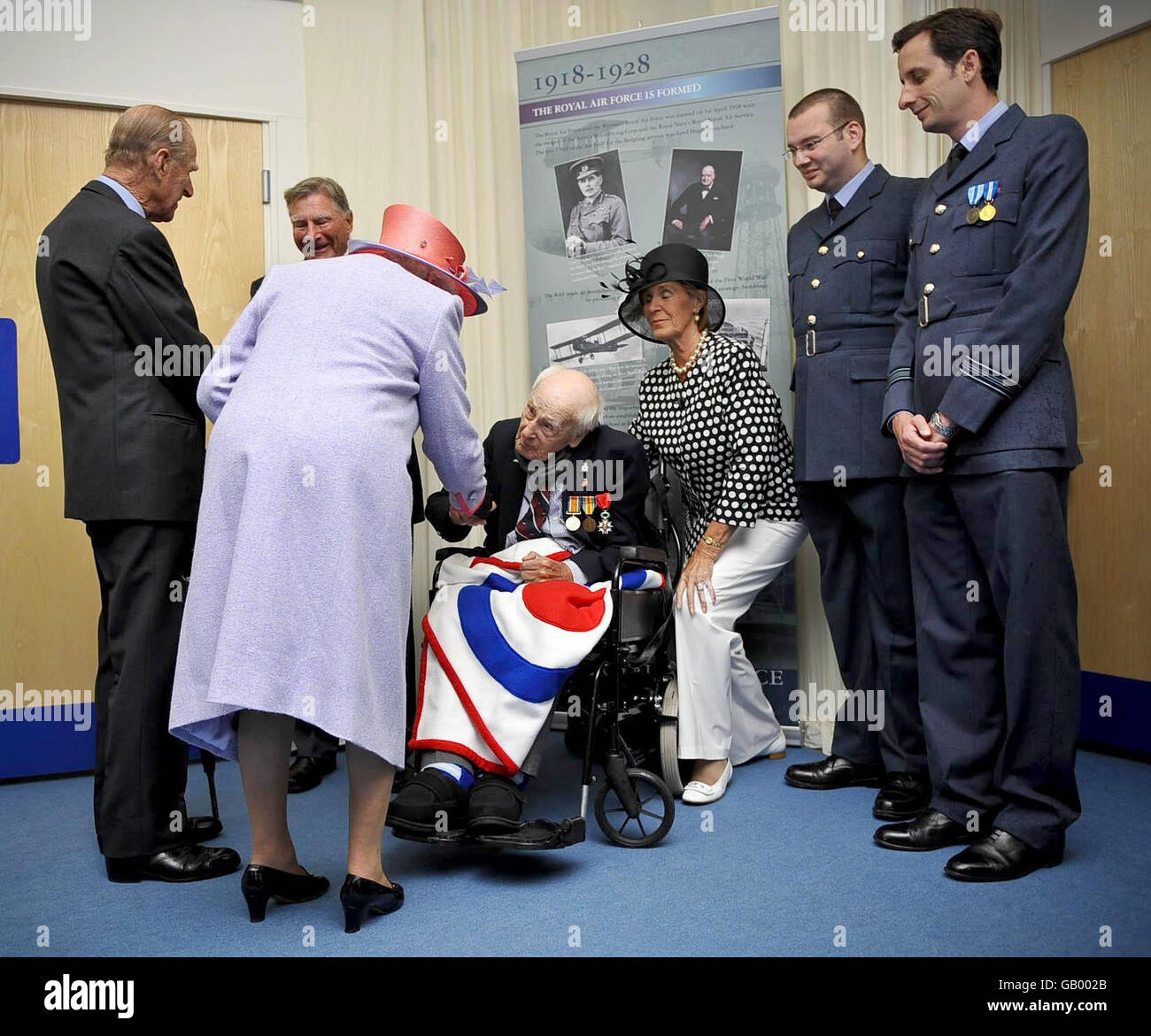 Britain's Queen Elizabeth II greets Henry Allingham, 112, who is the oldest surviving World War I veteran at RAF Fairford. Stock Photo