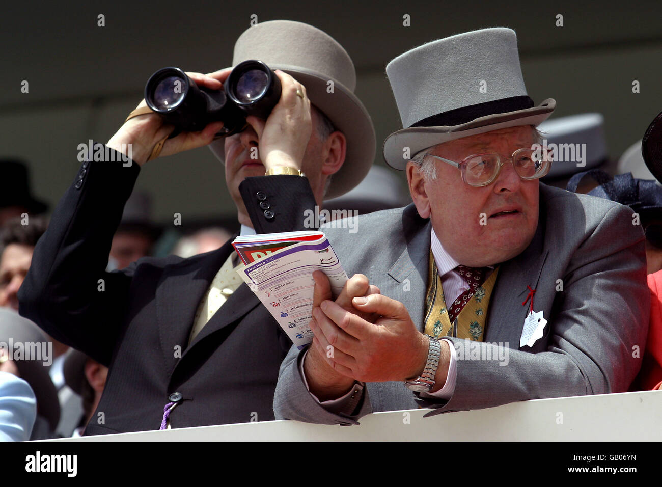 Spectators watch the race through binoculars from their balcony Stock