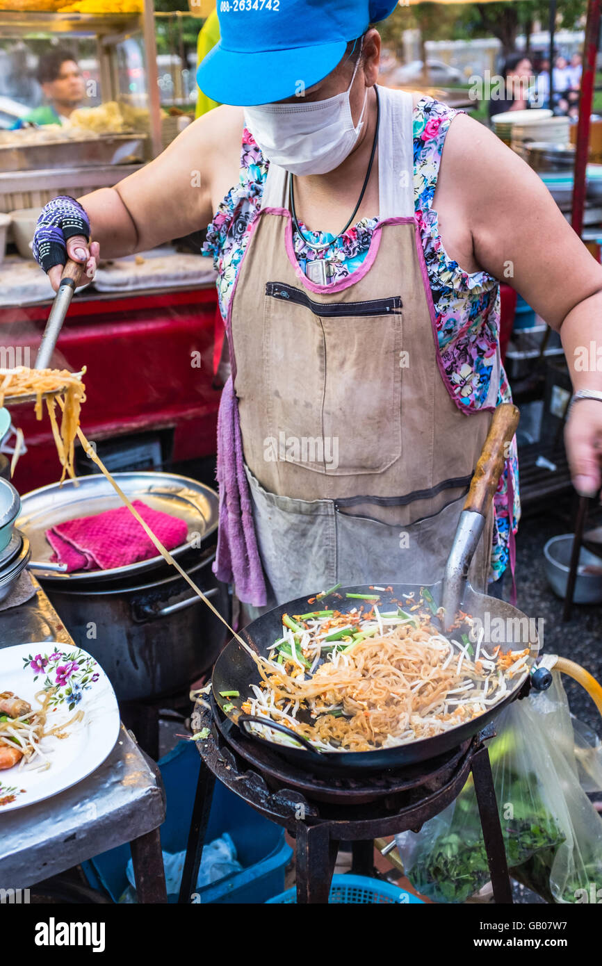 Lady Chef cooking stir fry Pad Thai in a wok,Thai street food market,Chiang Mai Thailand Stock Photo