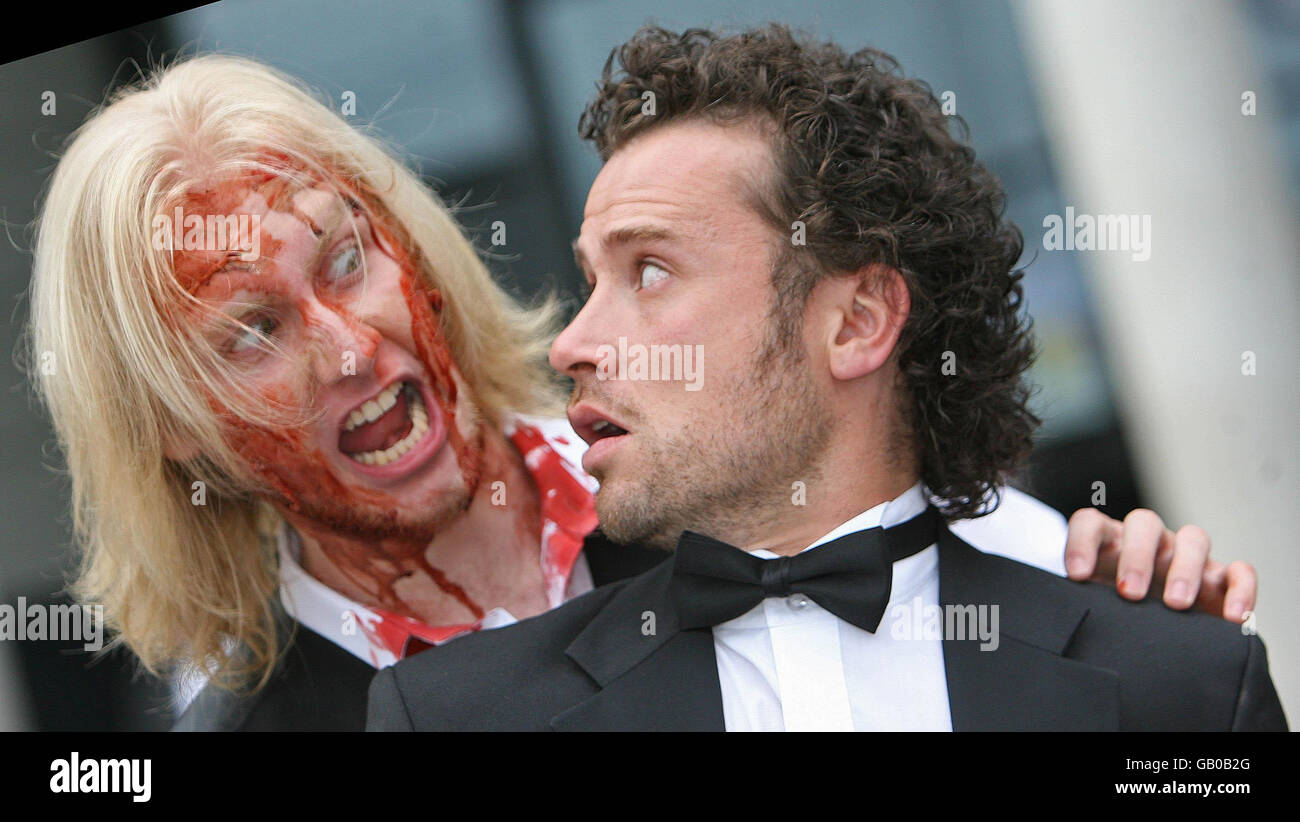 Actor Alan M Crawford is attacked by zombie Johnny Burmside at the premiere of Northern Ireland's first zombie horror film 'The Battle of the Bone' at the Odyssey Arena, Belfast. Stock Photo