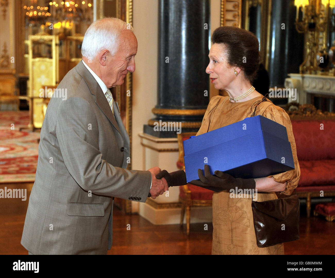 The Princess Royal shakes hands with Mr John Eversley before presenting him with a glass bowl, as a winner of the Queens award for enterprise, at Buckingham Palace, London. Stock Photo