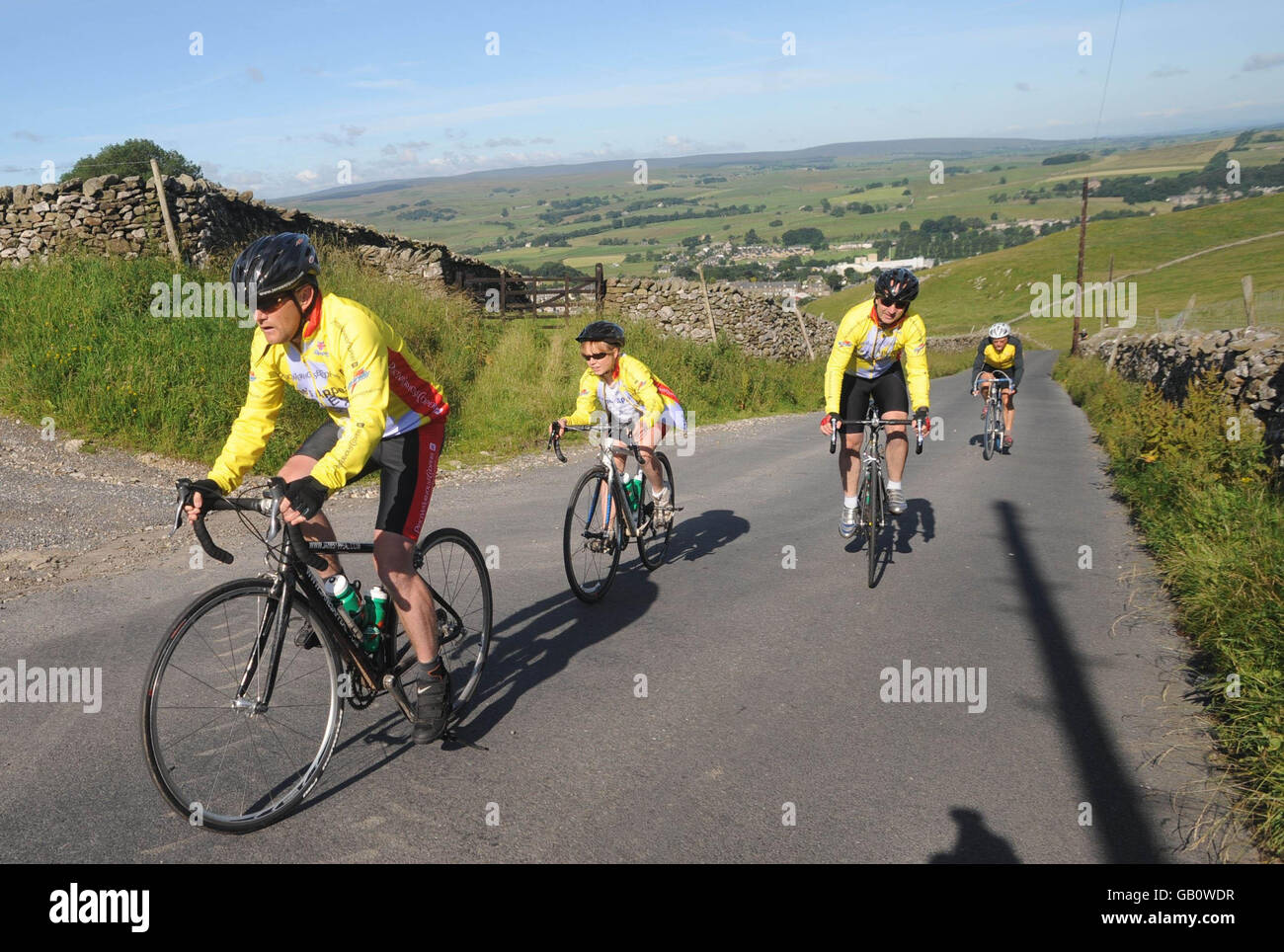 Mike Tomlinson (left) and Rebecca Tomlinson (second left), husband and daughter of the late Jane Tomlinson, cycle through countryside near Settle during the Yorkshire leg of the 1,400 mile Jane's Appeal End to End bike ride from John O'Groats to Land's End. Stock Photo