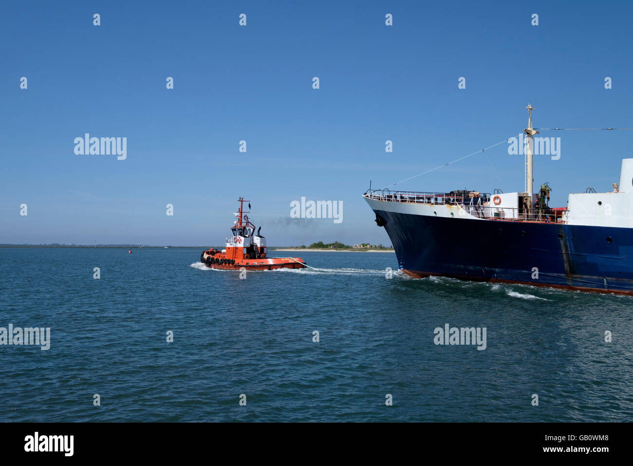 Tug boat pulling a ship Stock Photo
