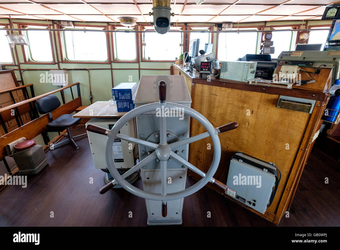Helm steering wheel in the navigation room of a freight ship Stock Photo