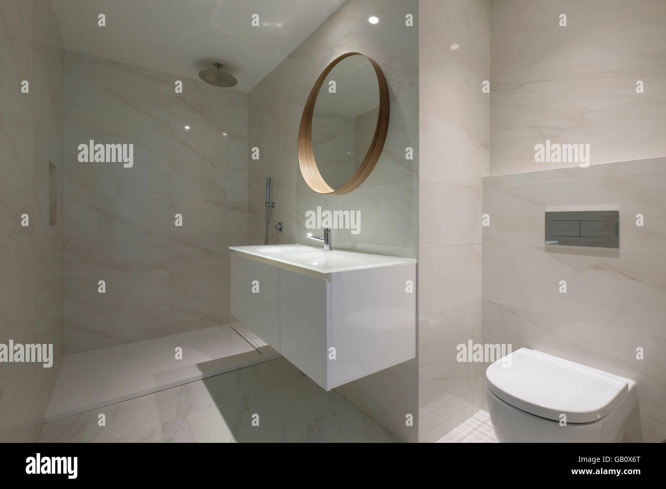 https://c8.alamy.com/comp/GB0X6T/modern-bathroom-with-marble-walls-and-a-big-round-mirror-GB0X6T.jpg