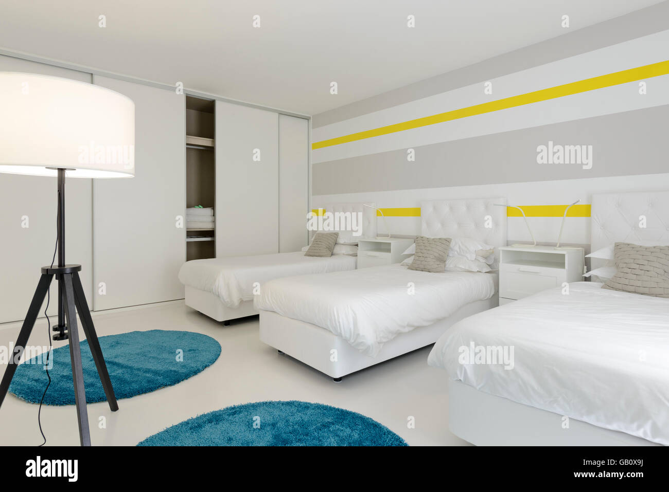 Three beds side by side in an hotel room Stock Photo