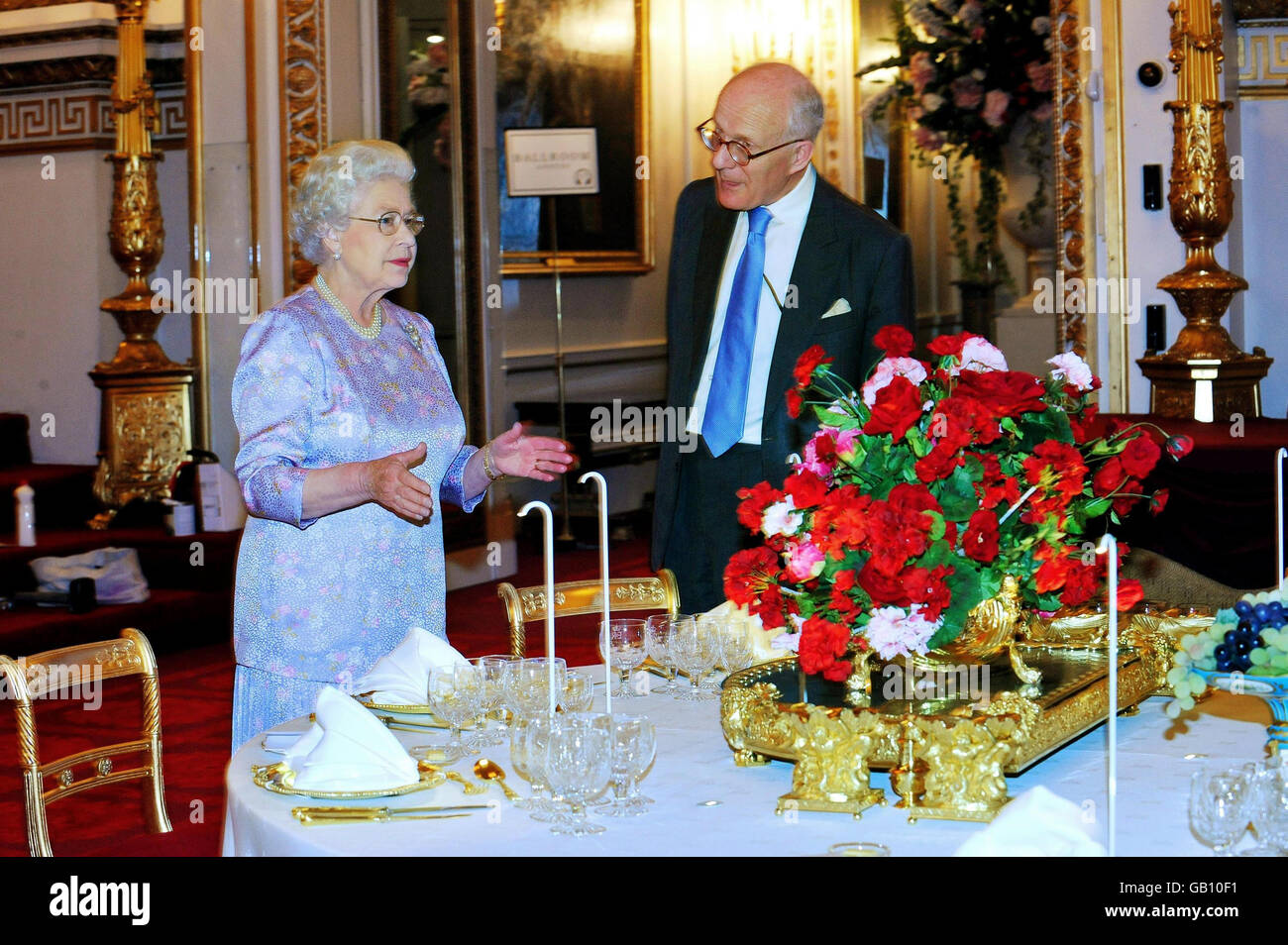Britain's Queen Elizabeth II, accompanied by the Director of the Royal Collection, Sir Hugh Roberts, views the Summer Opening exhibition at Buckingham Palace, London. The Ballroom has been arranged so that visitors can experience a real State Banquet. Stock Photo