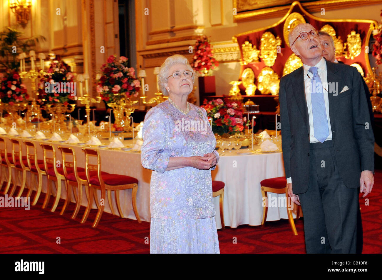 Britain's Queen Elizabeth II, accompanied by the Director of the Royal Collection, Sir Hugh Roberts, views the Summer Opening exhibition at Buckingham Palace, London. The Ballroom has been arranged so that visitors can experience a real State Banquet. Stock Photo
