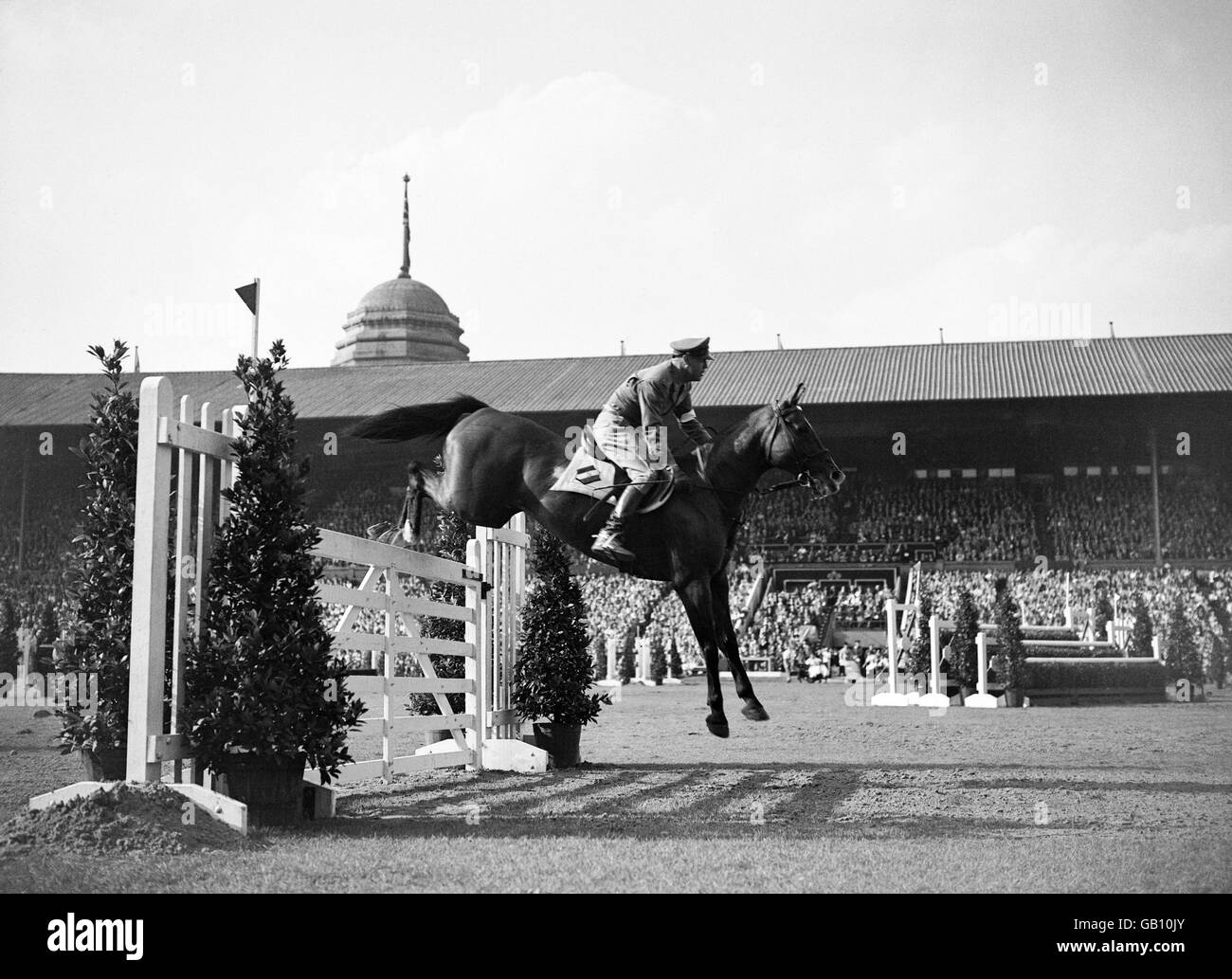 One of the competitors jumping a fence during the Prix Des Nations. Stock Photo