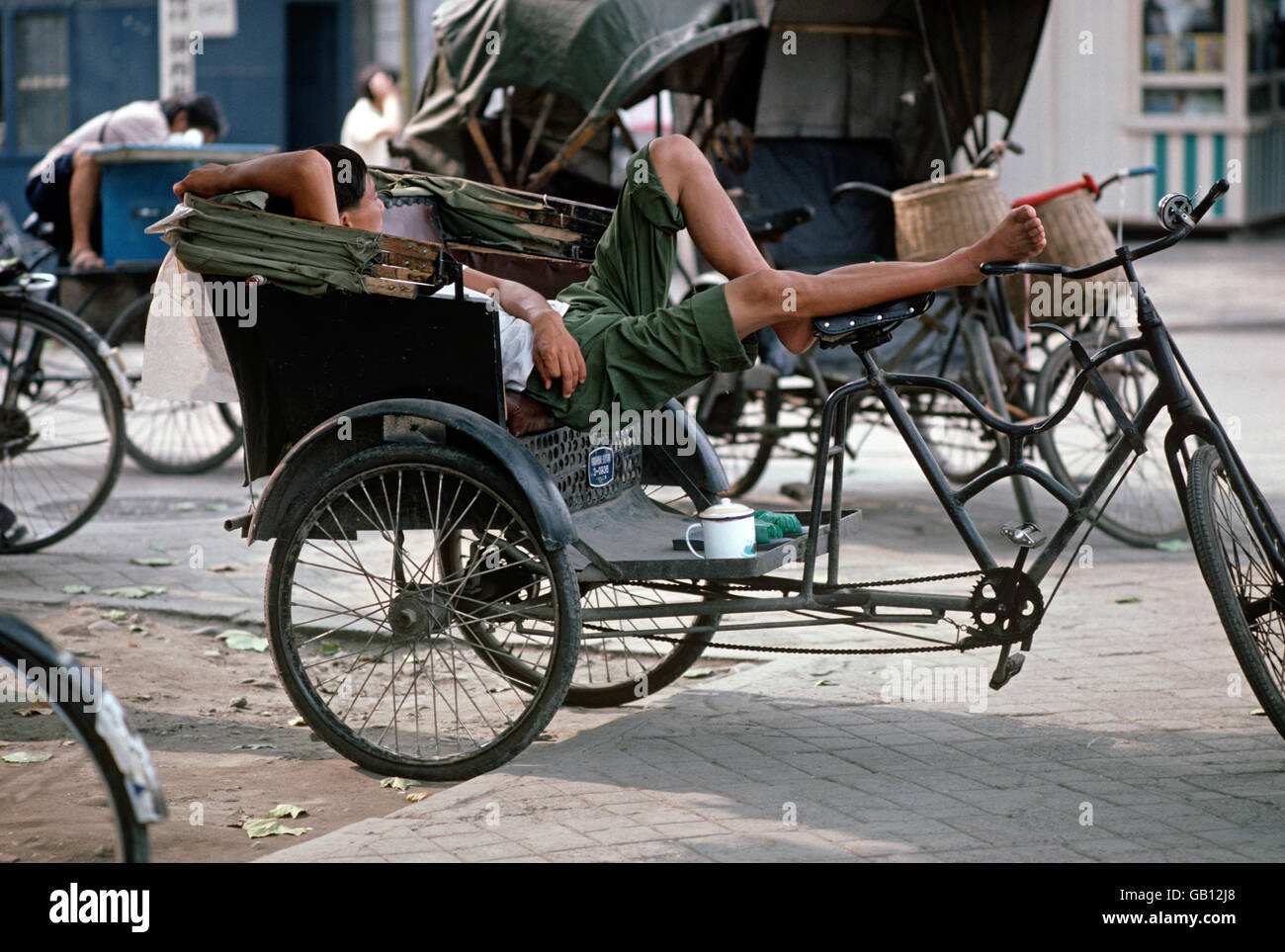 Bicycle taxi cyclist resting between fares, Chengdu, Sichuan Province, China Stock Photo