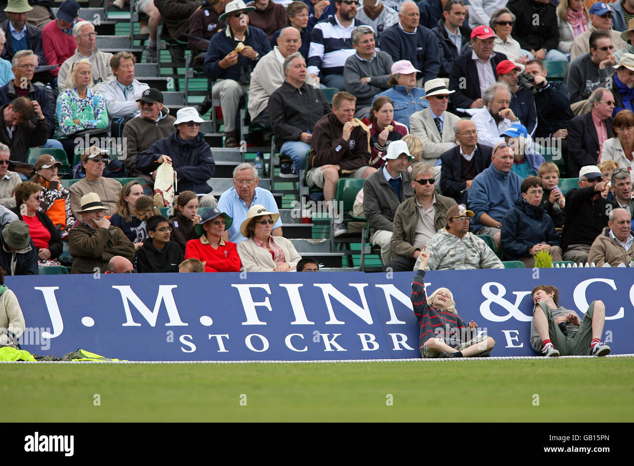 Fans and spectators enjoy the game from behind the boundary rope, at Guildford Cricket Club. Stock Photo