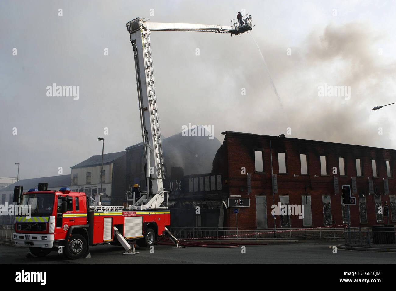 Firefighters damp down following a fire at an office block in Bolton town centre. Stock Photo