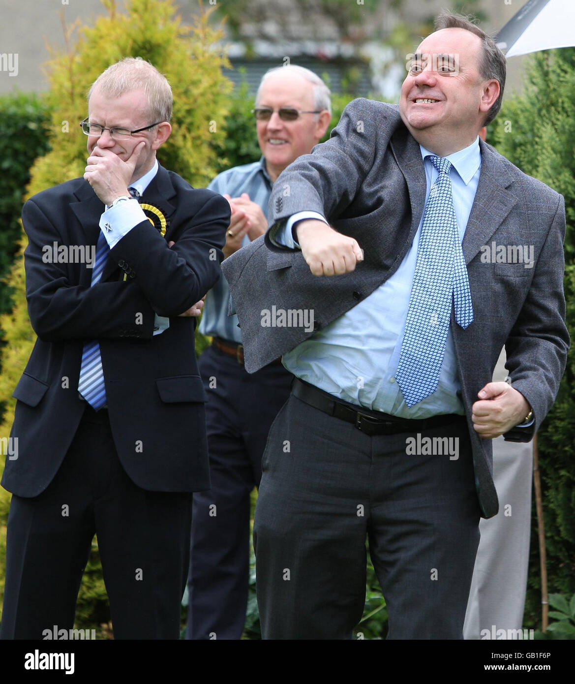 SNP candidate for Glasgow East, John Mason with First Minister Alex Salmond (right) who punched the air after a good shot during a game of bowls while visiting Garrowhill Bowling Club, to highlight support for pensioners in the citys east end. Stock Photo