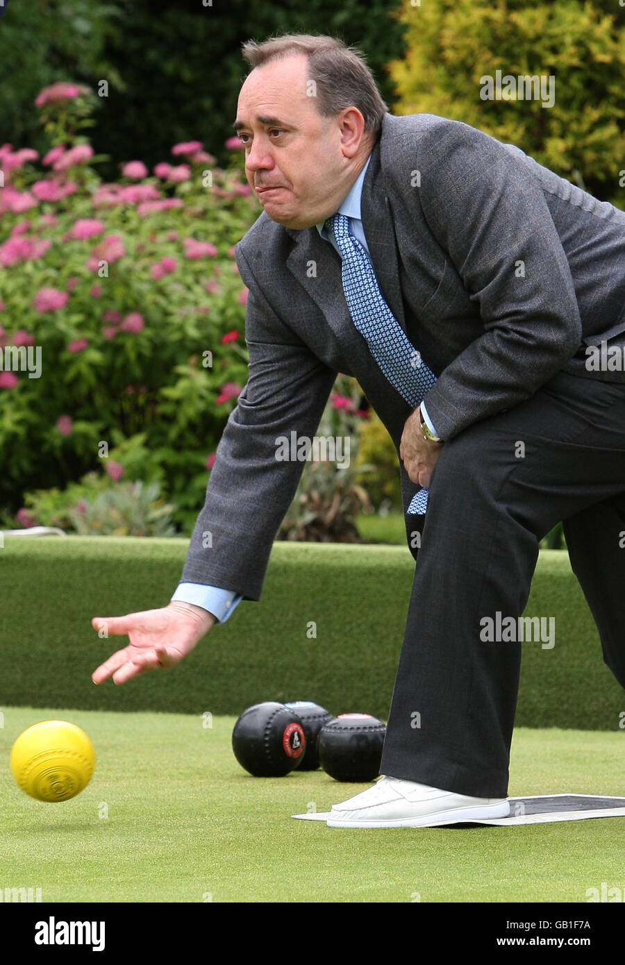 First Minister Alex Salmond plays a shot during a game of bowls while visiting Garrowhill Bowling Club, to highlight support for pensioners in the citys east end. Stock Photo