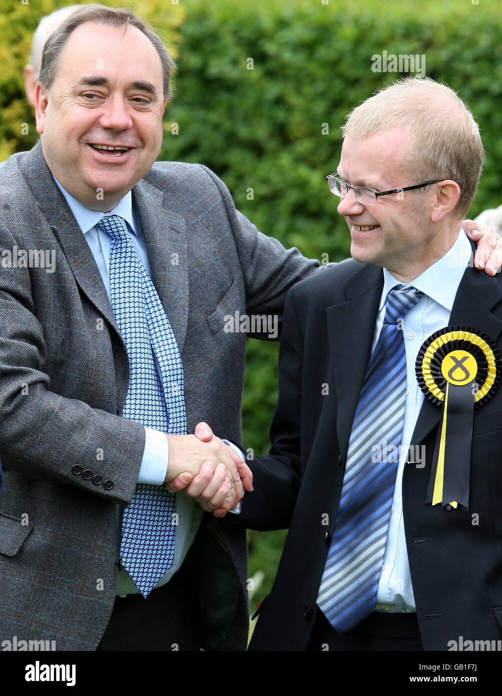 First Minister Alex Salmond (left) shakes hands with SNP candidate for Glasgow East, John Mason, while visiting Garrowhill Bowling Club, to highlight support for pensioners in the citys east end. Stock Photo